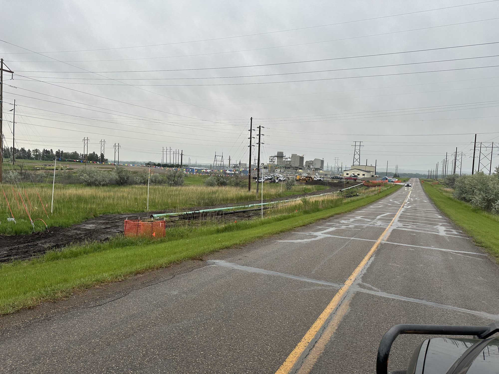 Pipe laid out beside a plant access road
